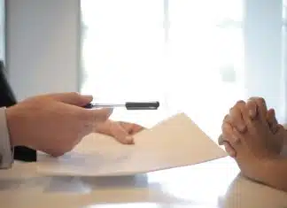 Crop businessman giving contract to woman to sign