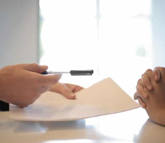Crop businessman giving contract to woman to sign
