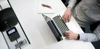 person using laptop on white wooden table