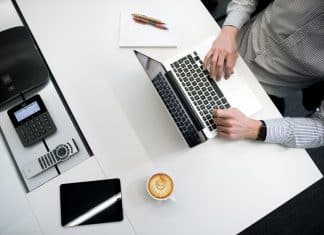 person using laptop on white wooden table