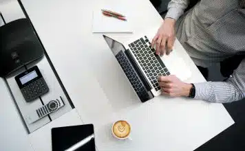 person using laptop on white wooden table