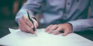 man writing on paper
